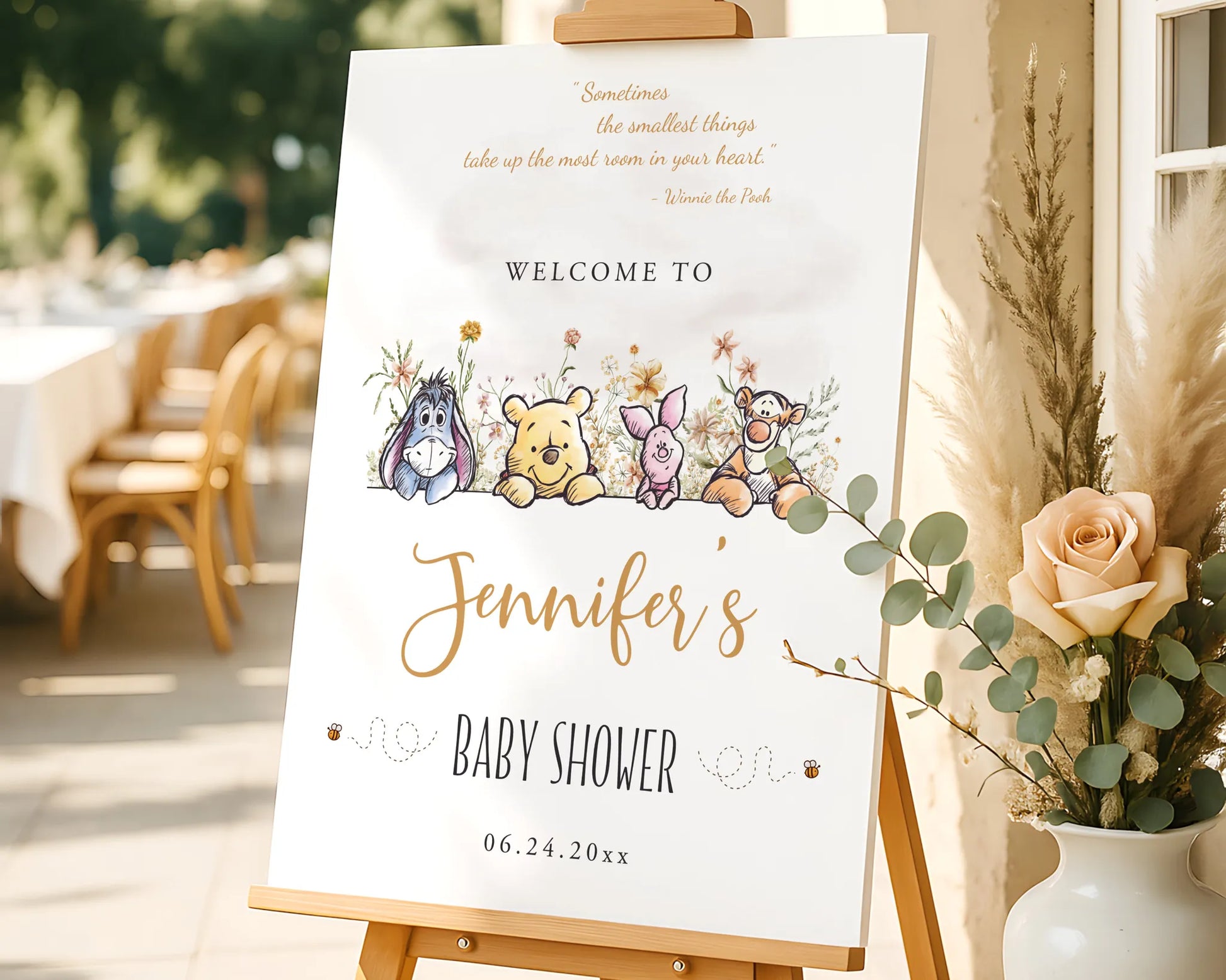 Personalized Winnie the Pooh entrance door decor displayed on an easel with neutral flowers