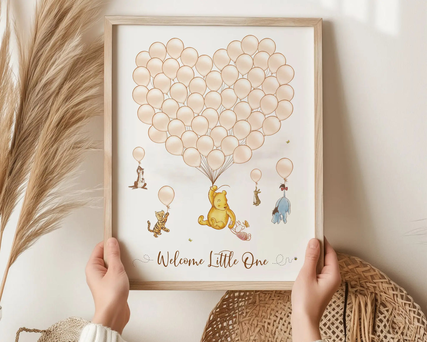 Winnie the Pooh baby shower guest book in beige tones with heart balloon cluster and Pooh characters, held by hands in natural boho setting.