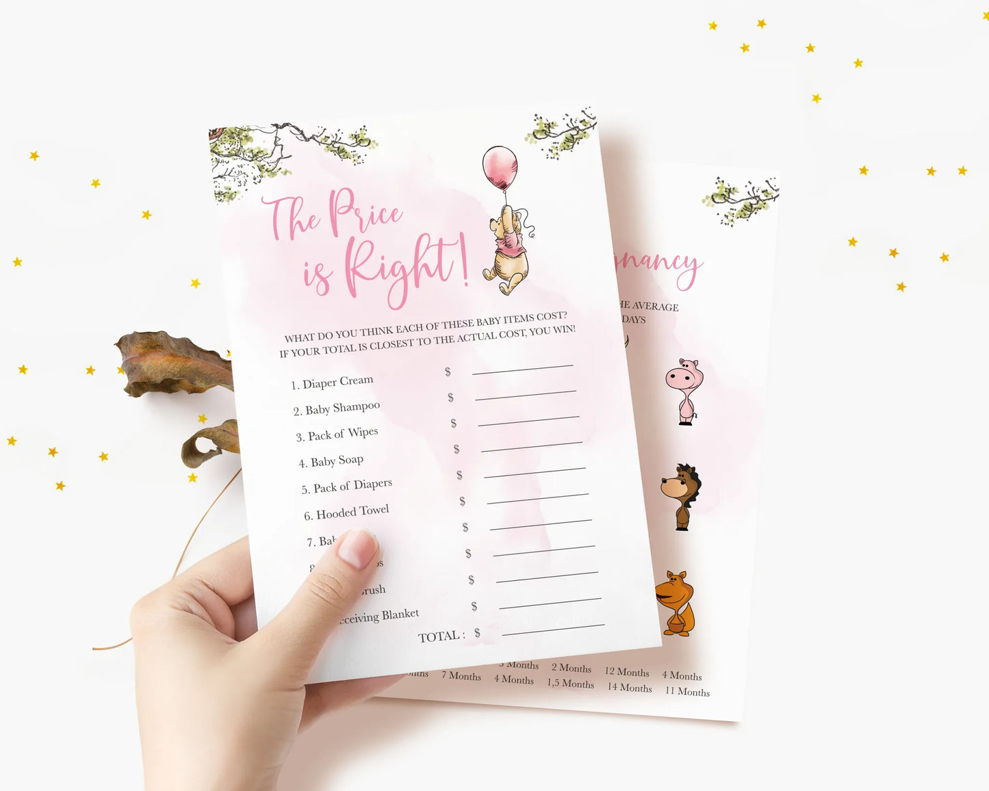 Hand holding The Price is Right baby shower game card featuring Winnie the Pooh and pink accents
