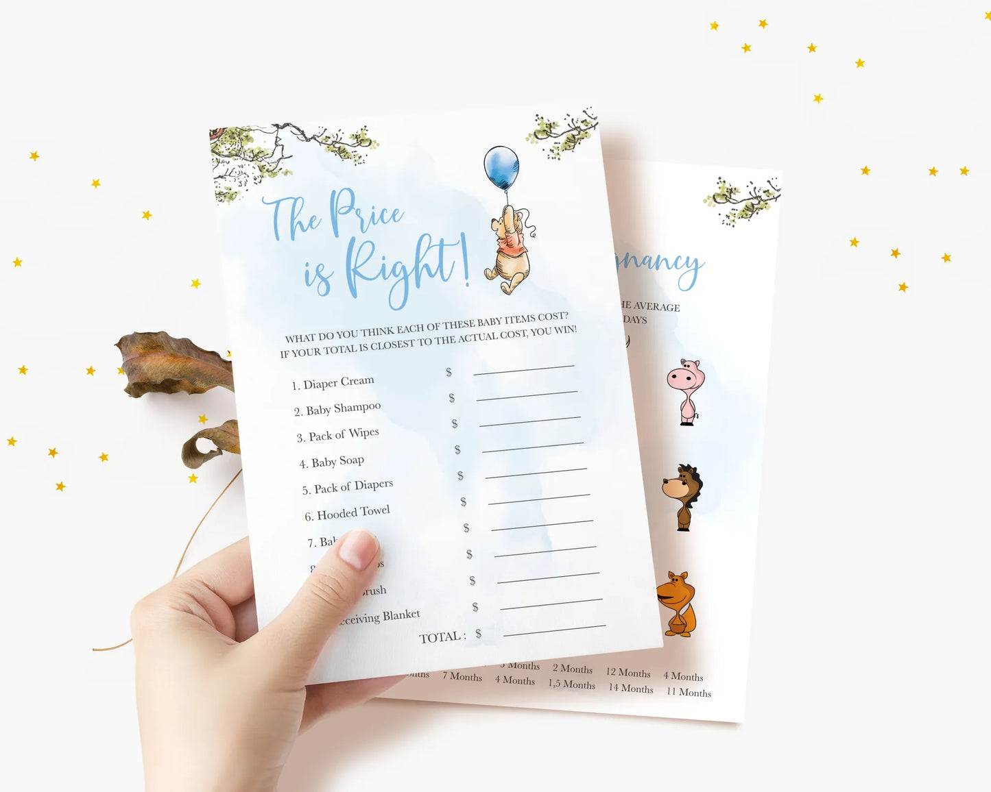 Hand holding The Price is Right baby shower game card featuring Winnie the Pooh and blue accents